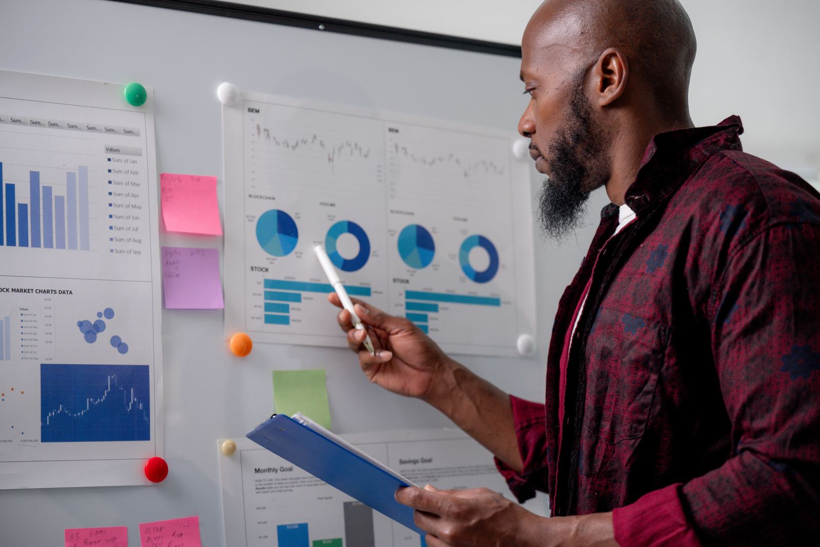 A man analysing charts and data on a large whiteboard in a bright office