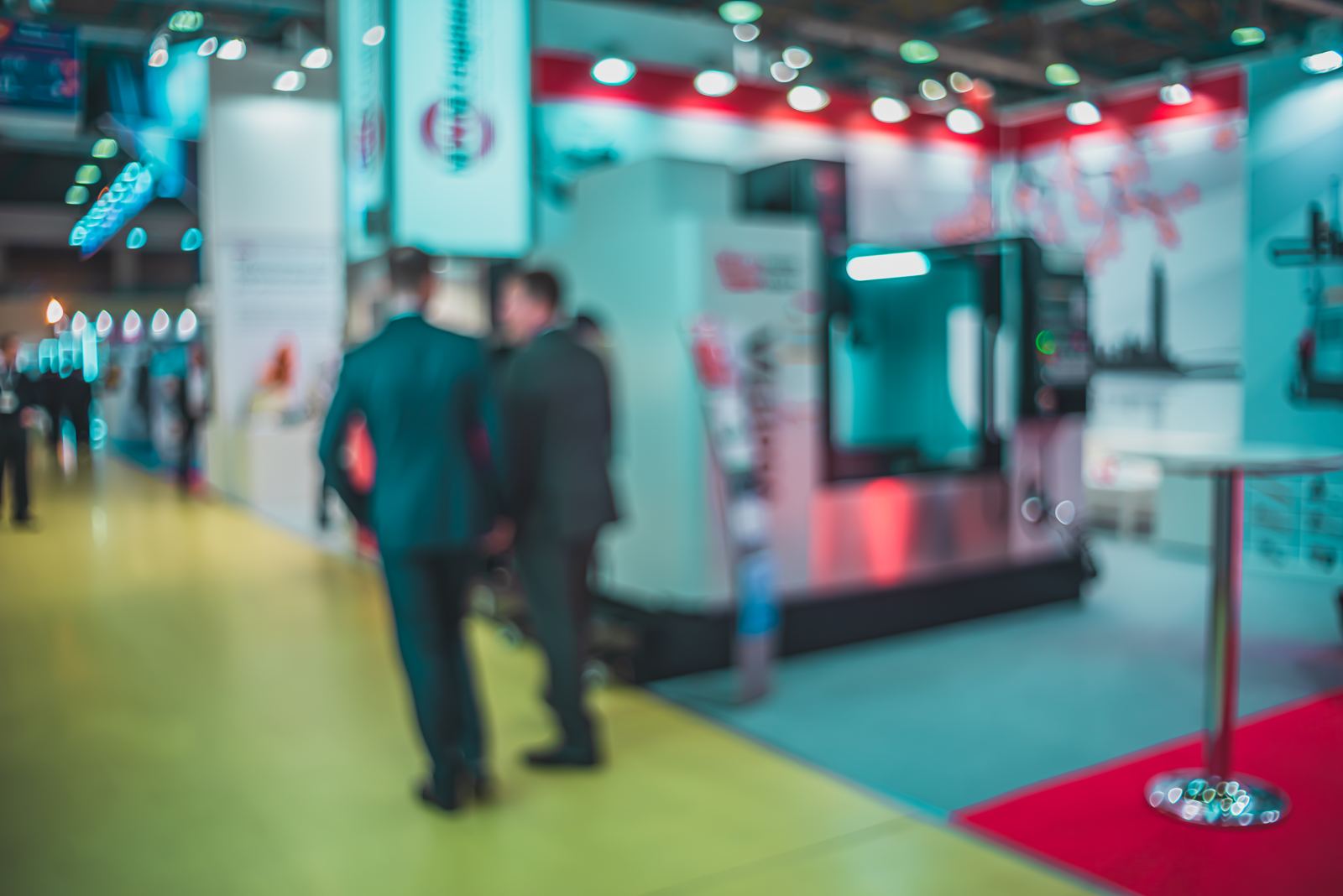 Business visitors walking through a busy trade fair hall with exhibition stands